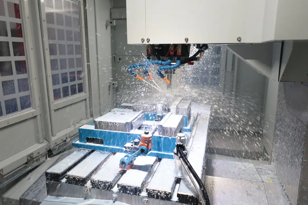 CNC milling machine with coolant spray cutting metal workpiece on industrial bed